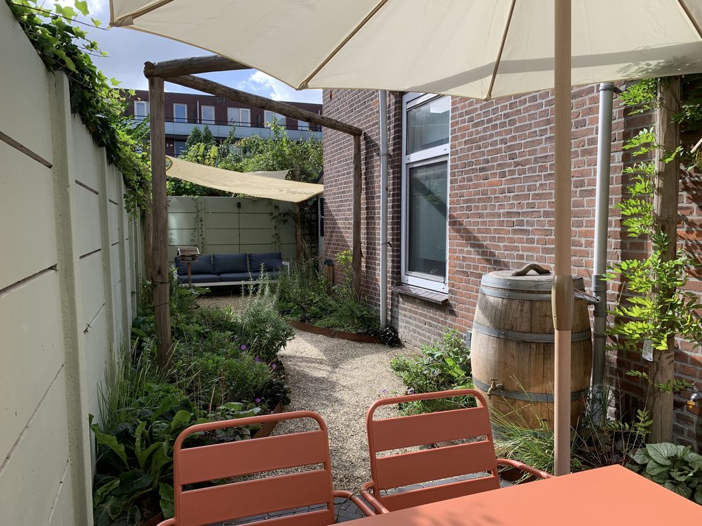 Uitzicht vanuit de woonkamer op de groene stadstuin