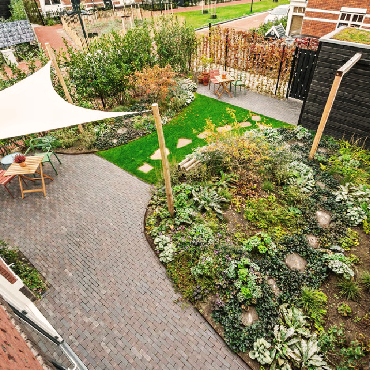 Groene stadstuin in Den Haag met tarp op kastanjepalen en weelderige beplanting